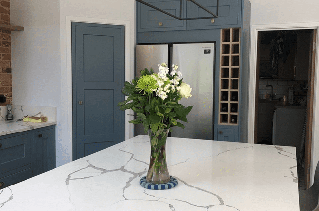 A look at the white quartz countertops and black island lighting in Rebecca's industrial kitchen.