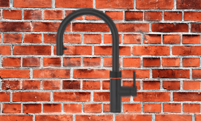 Quooker boiling water taps help to save counter space and ties in with this industrial kitchen's other black details.