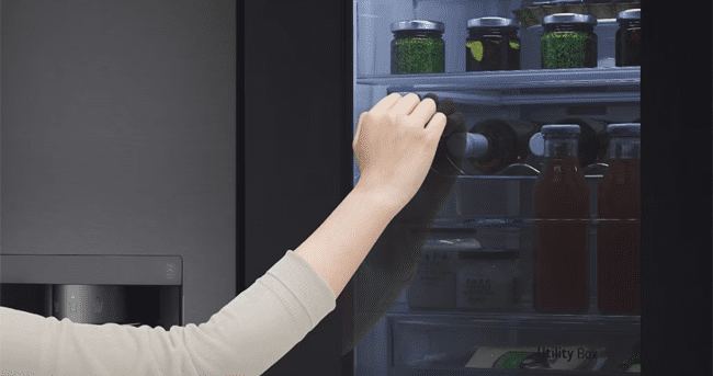 This image features a hand reaching up to knock on an LG interview fridge door.