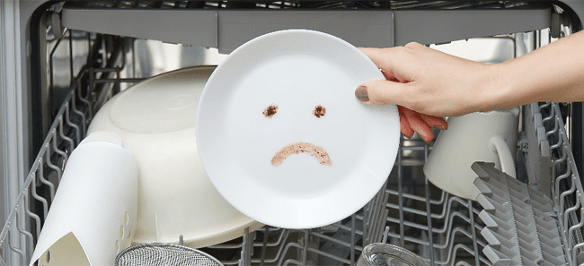 Handing taking a plate with a sad face out of a dishwasher