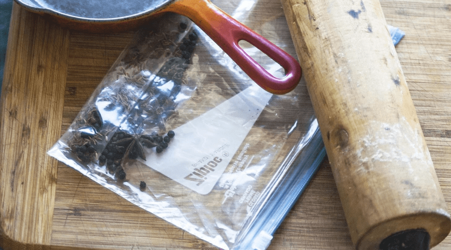 Ziplock bag of herbs next to frying pan and rolling pin