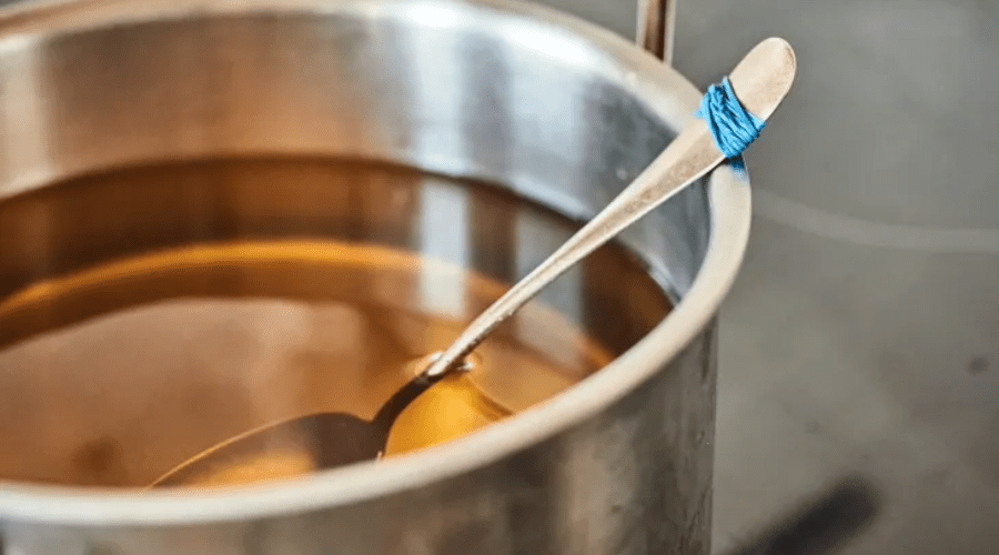 Rubber band on spoon to hold it up in pot