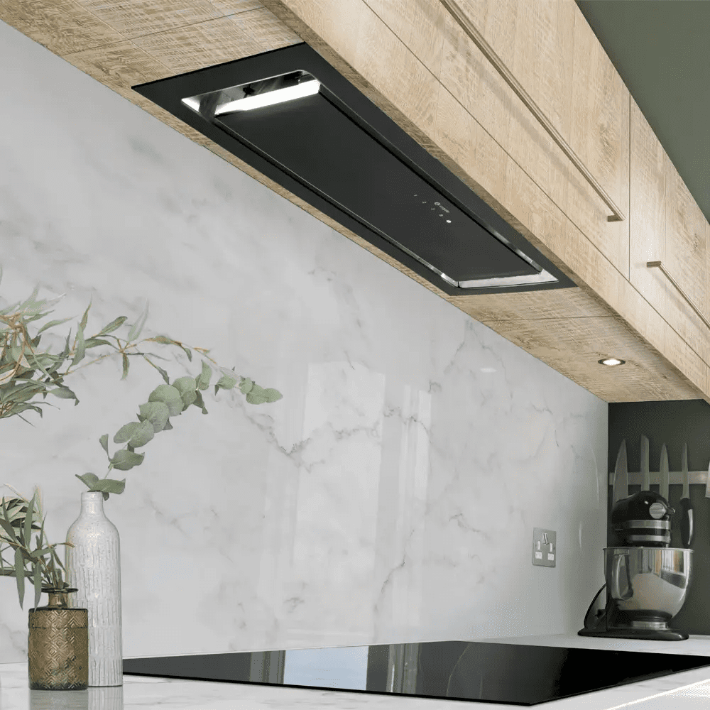 Lifestyle image of a Caple canopy hood in black, positioned above a black Caple induction hob.