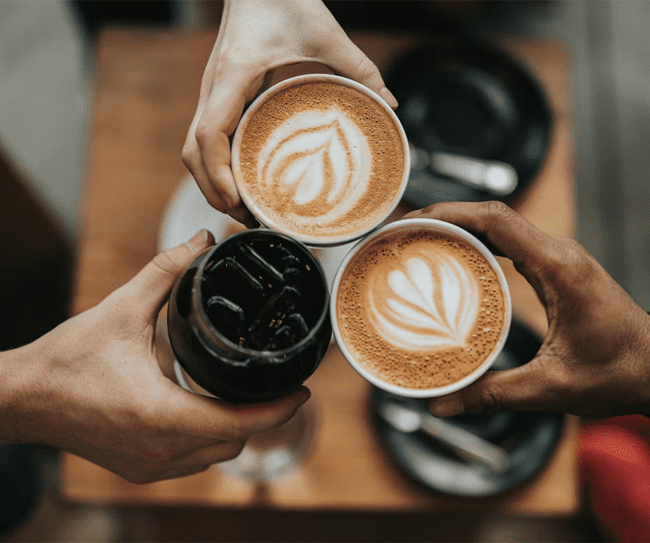 3 hands holding 3 cups of coffee