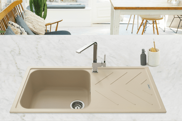 Close up of a beige Caple composite sink with a right hand side drainer. Set into a white stone worktop.