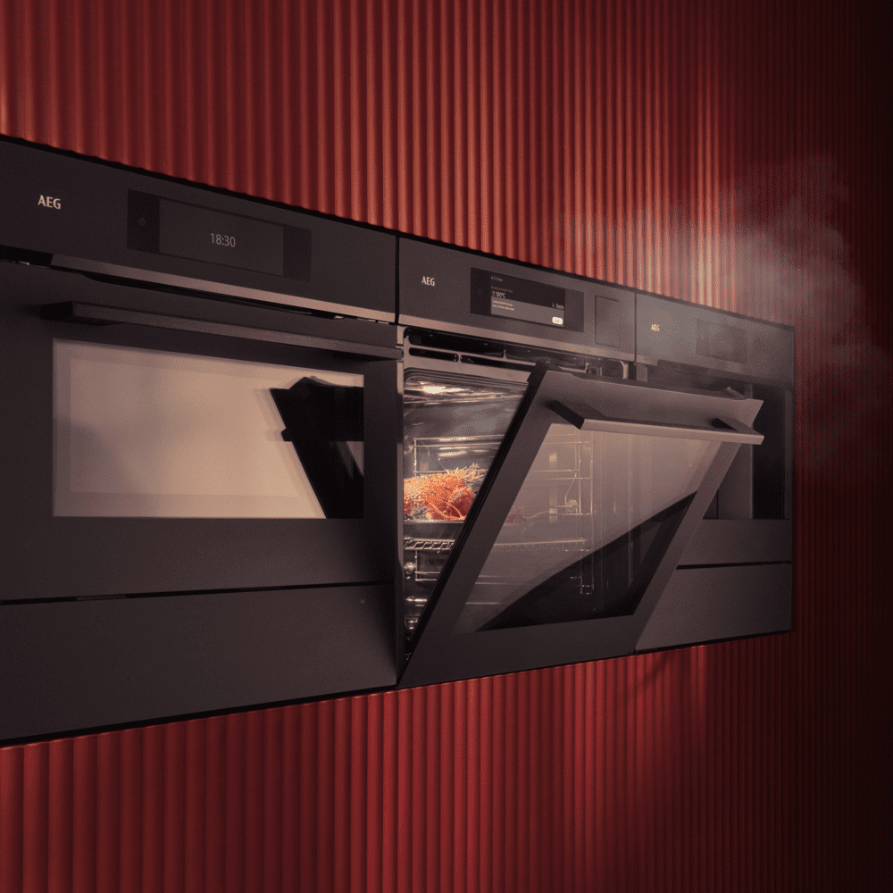 Close up of a bank of AEG built in cooking appliances including a conventional oven, microwave and steam oven