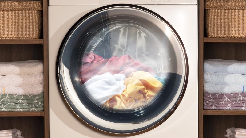 White Haier washing machine during a cycle. The drum is filled with laundry.