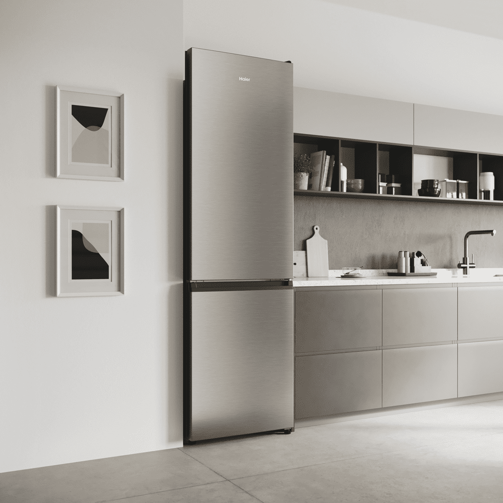 A Haier freestanding fridge freezer in a white and light grey kitchen.