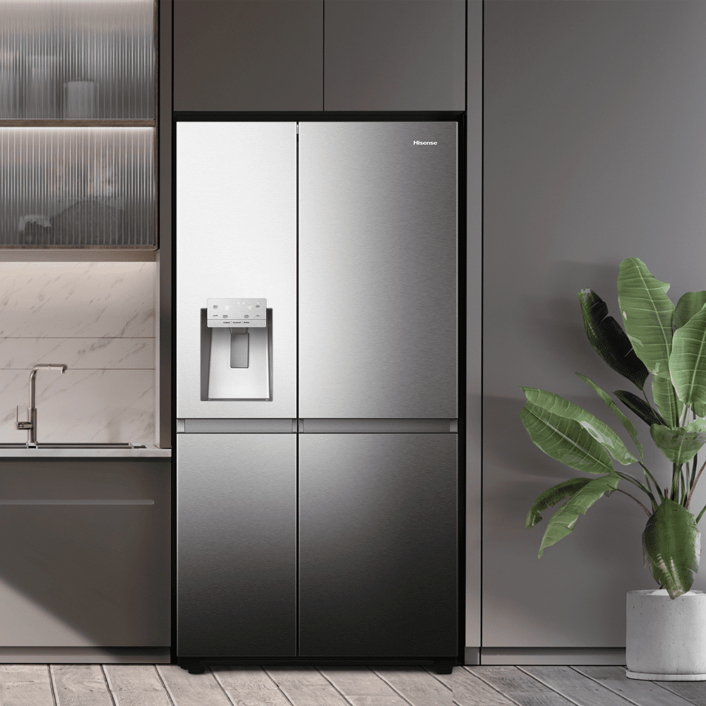 A lifestyle image of a light grey kitchen featuring a stainless steel American style fridge freezer.
