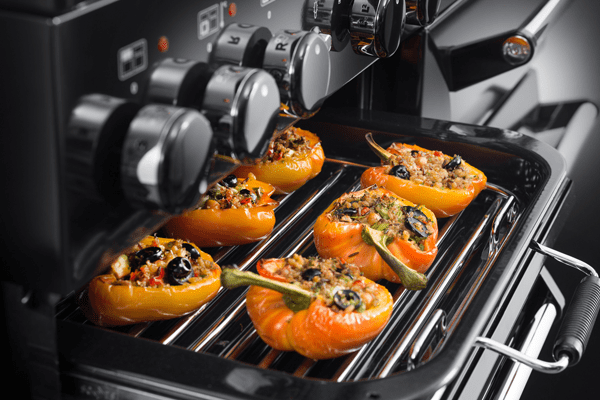 A close up image of the glide out grill in an AGA Masterchef range cooker. Stuffed yellow peppers are in the grill in this image.