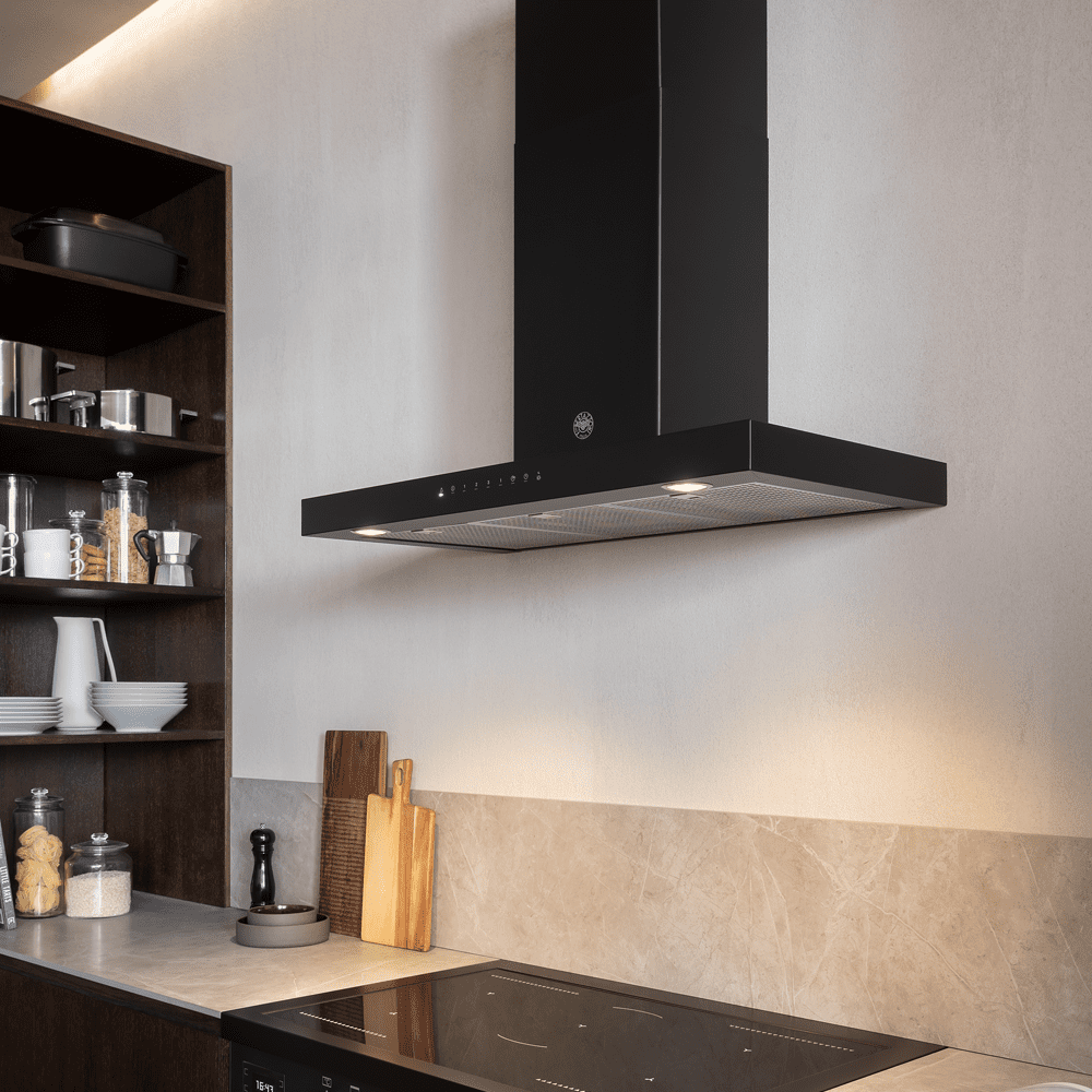 A black Bertazzoni cooker hood positioned over an induction hob