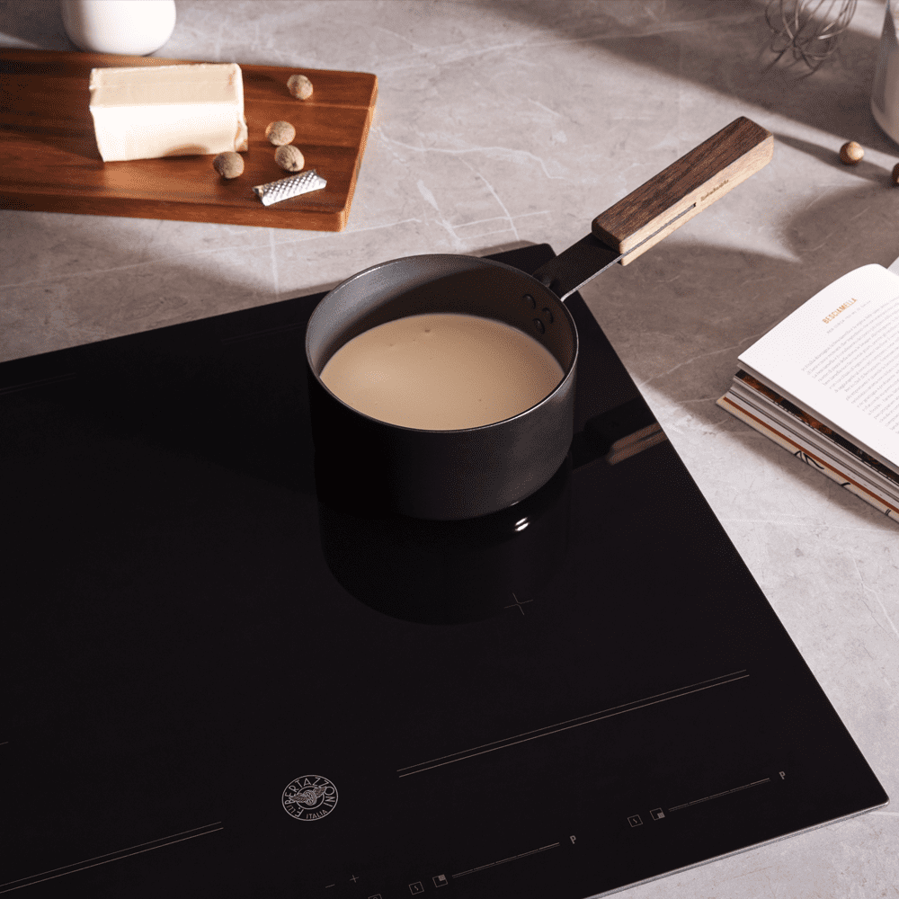 Bertazzoni induction hob with a pan of milk simmering on top of it.