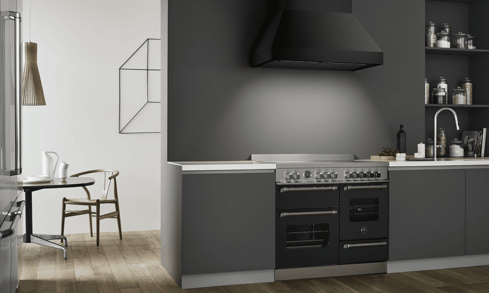 Image of a modern grey kitchen featuring a Bertazzoni Master Series range cooker and chimney hood, both finished in black.