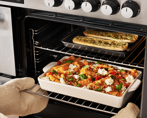 Close up image of a pasta bake and garlic bread cooking in a Belling range cooker main oven cavity