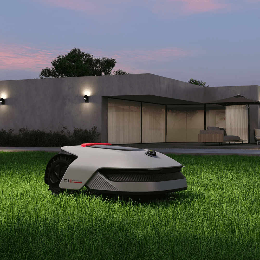 Lifestyle image of a Dreame robot lawn mower outside a modern house, positioned on the grass.