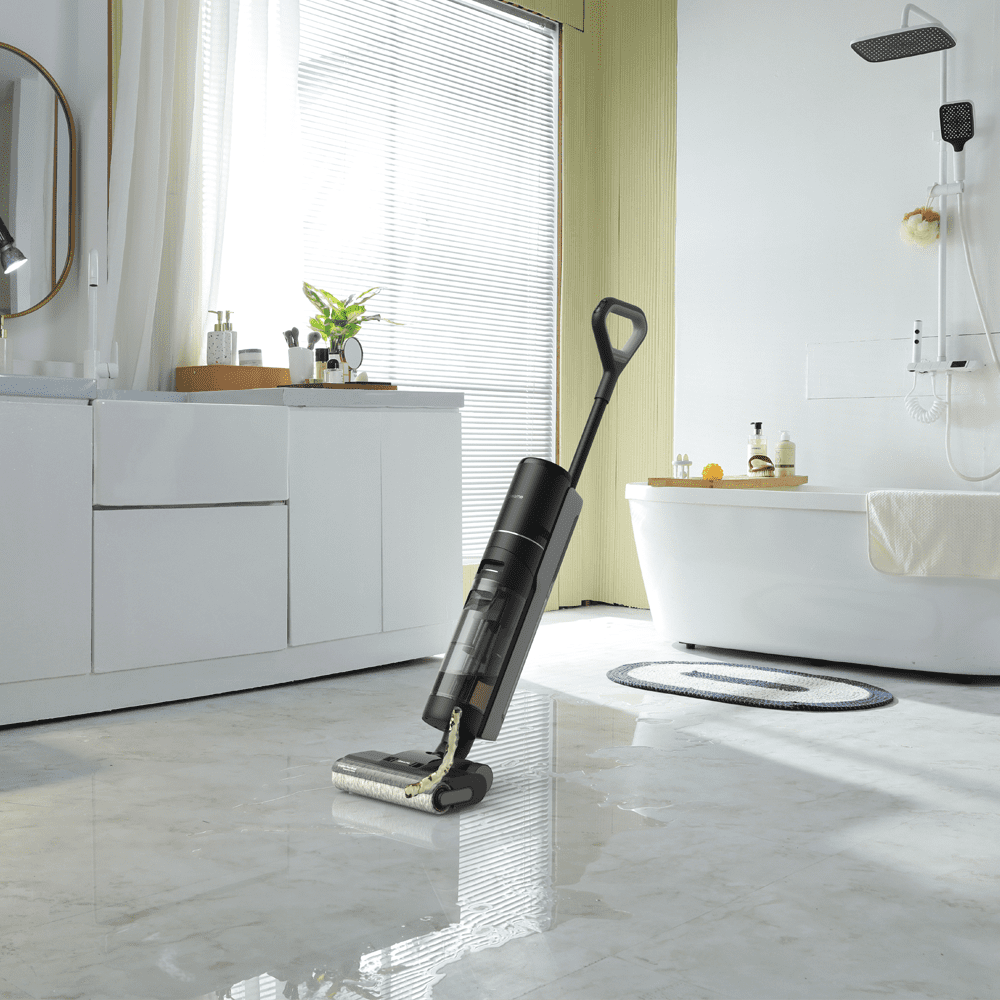Image of a Dreame wet & dry vacuum cleaner in a light and airy white bathroom. Cleaning up a puddle of water from the floor.