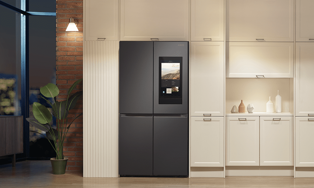 A Samsung Family Hub American style fridge freezer positioned in a modern open plan cream kitchen.