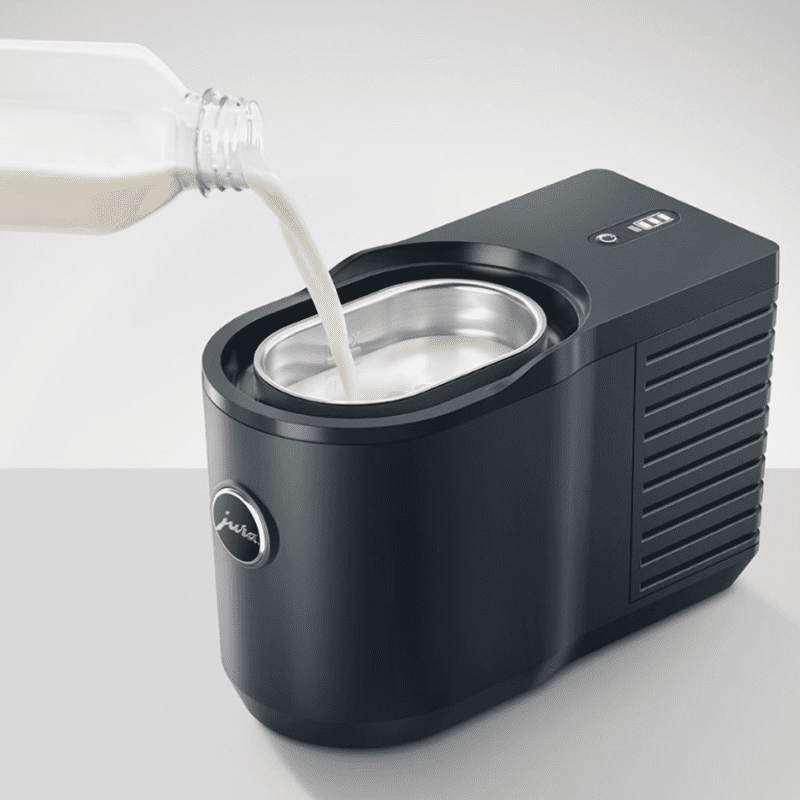 Jura Cool Control milk cooler with milk being poured into it.