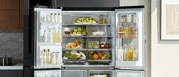 Image of an LG French style fridge freezer with two top doors open to showcase the vast space inside the fridge compartment.