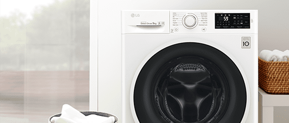 Image of an LG white washing machine with a pile of white laundry beside it in a basket