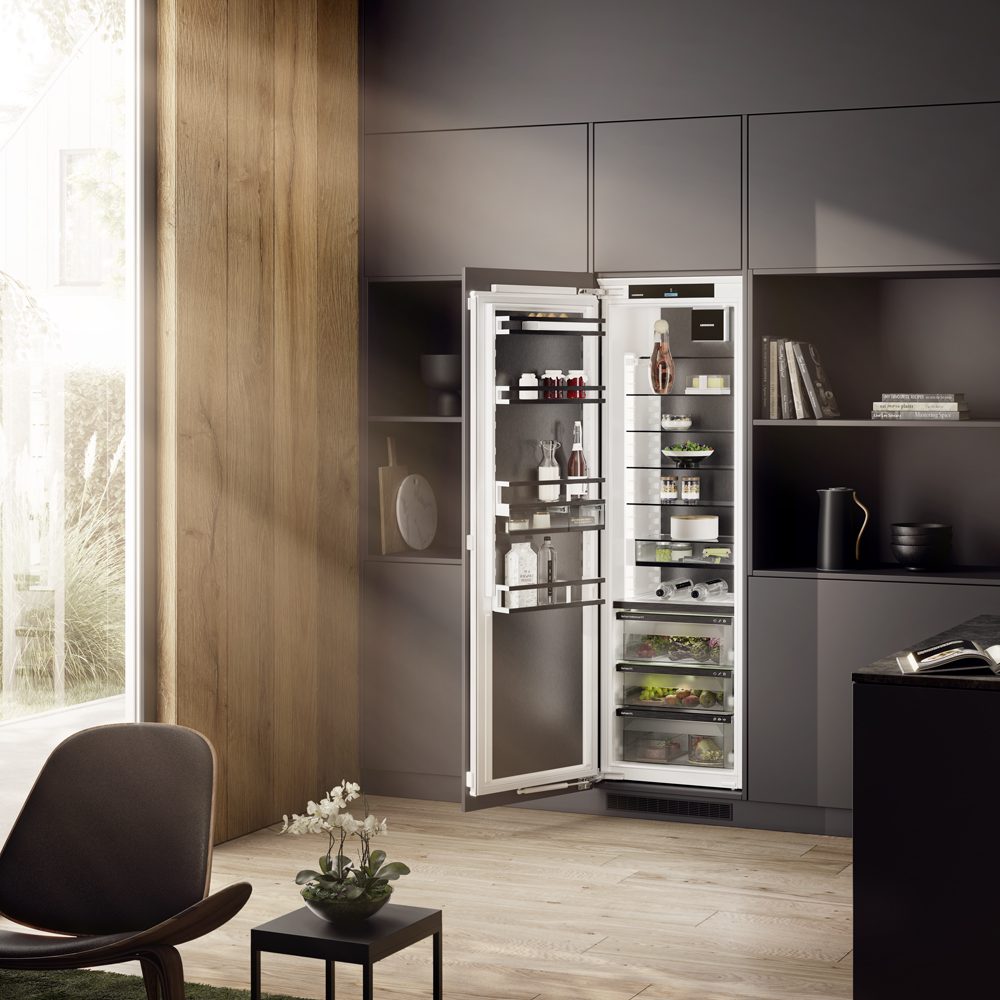 Liebherr full height fridge with it's door open so you can see the contents inside. The integrated fridge is fitted in a modern grey kitchen.