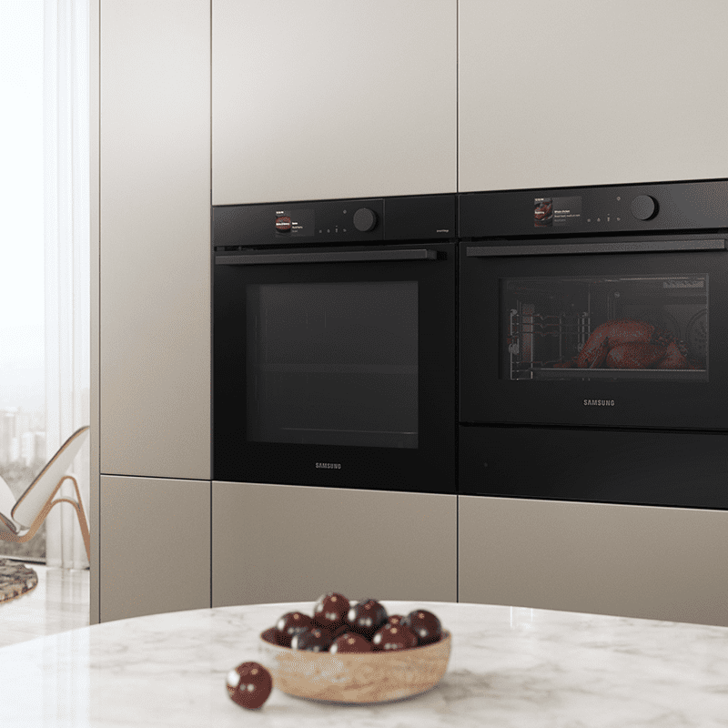 Image of a Samsung built in single oven alongside a combination microwave and warming drawer. Built into a beige tall housing unit.