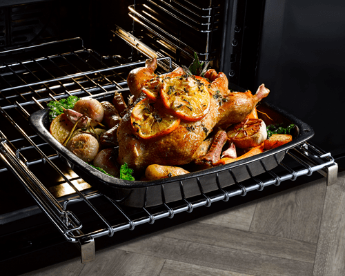 Close up of a roast chicken on an oven shelf featuring telescopic rails