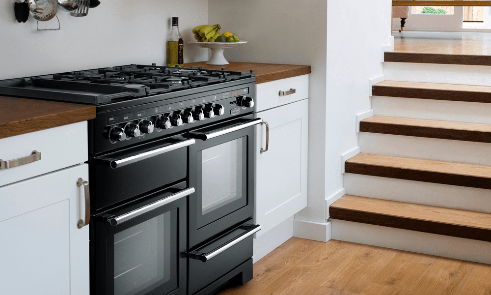 Rangemaster Encore Deluxe finished in black in a white kitchen with wooden worktops