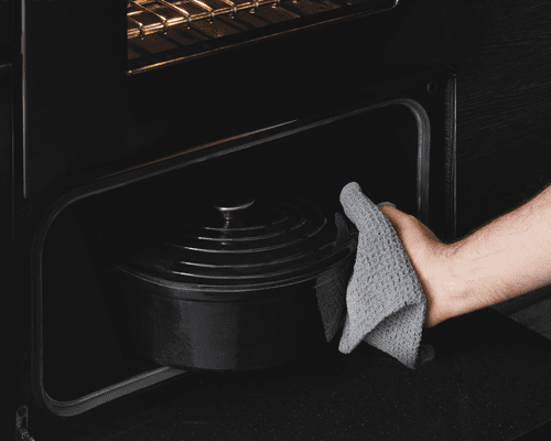 Close up of a crock pot being placed inside the dedicated slow cook oven inside a Stoves range cooker