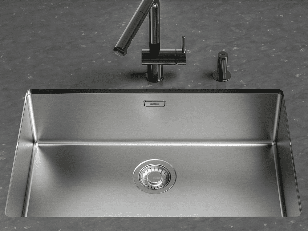 Close up of a Franke stainless steel single bowl sink undermount into a black granite worktop.