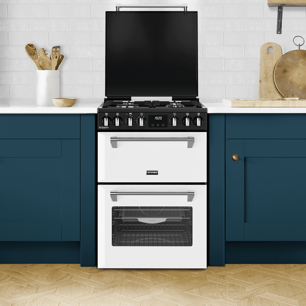 Image of a white dual fuel Stoves mini range cooker in a modern blue and white kitchen with a wooden floor.