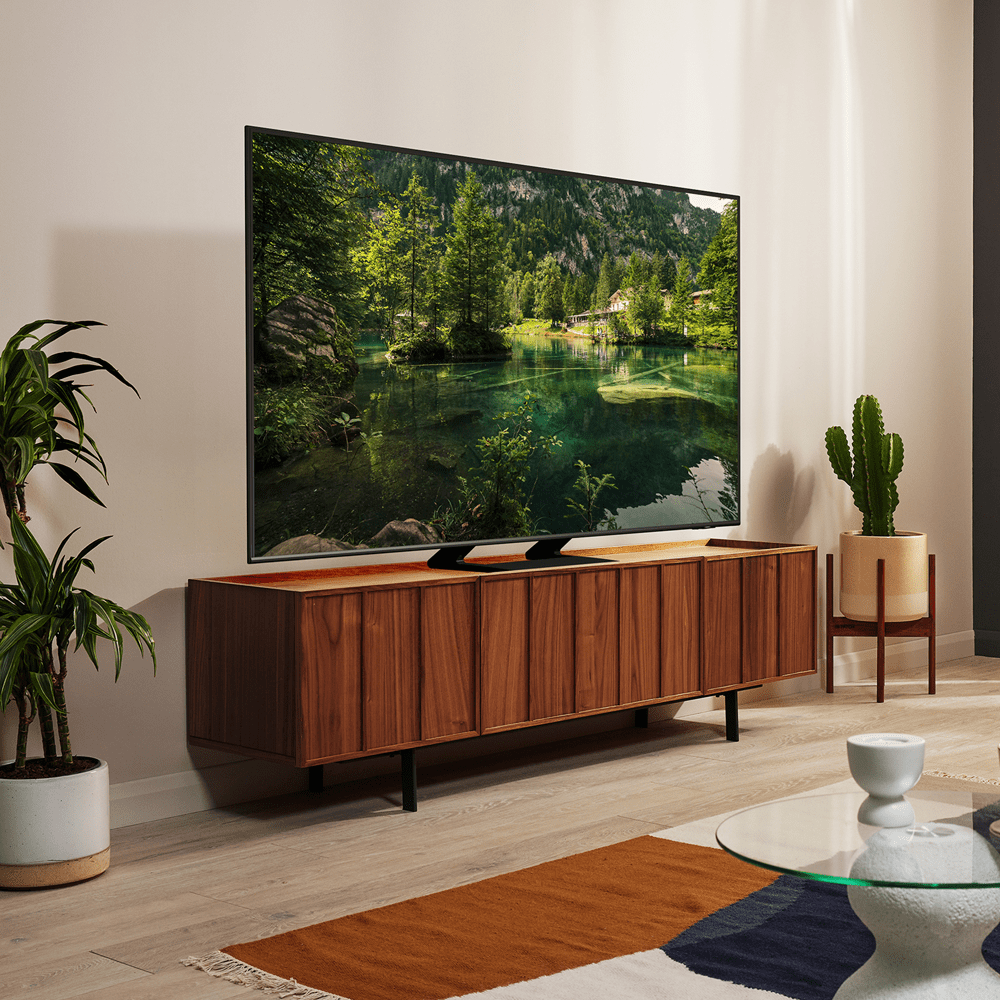 Image of a large flatscreen Samsung TV on a wooden TV unit.