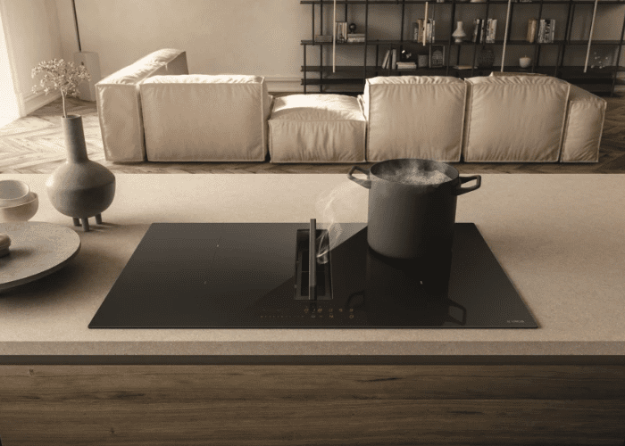 A NikolaTesla Fit in a brown and cream kitchen with a boiling pot situated on the hob.