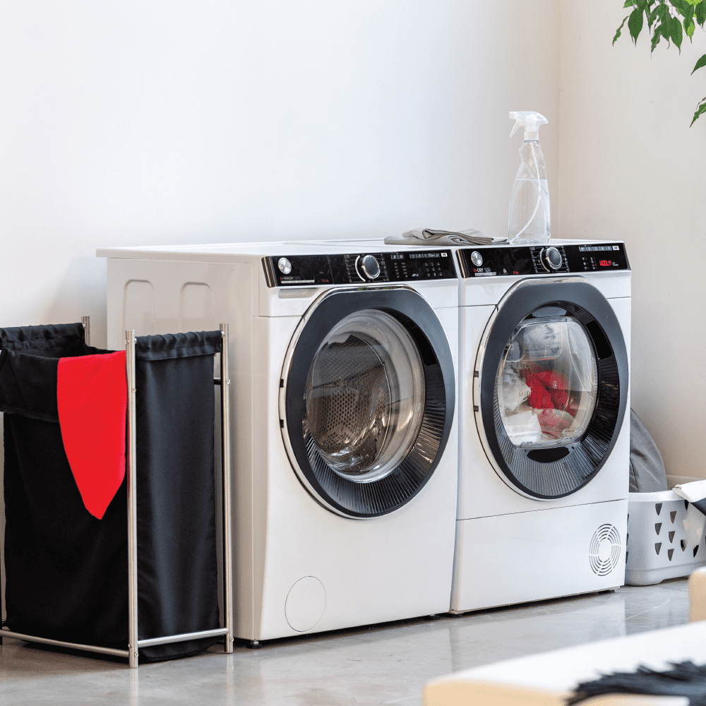 Image of two Hoover freestanding laundry appliances finished in white, in a white minimal style room.