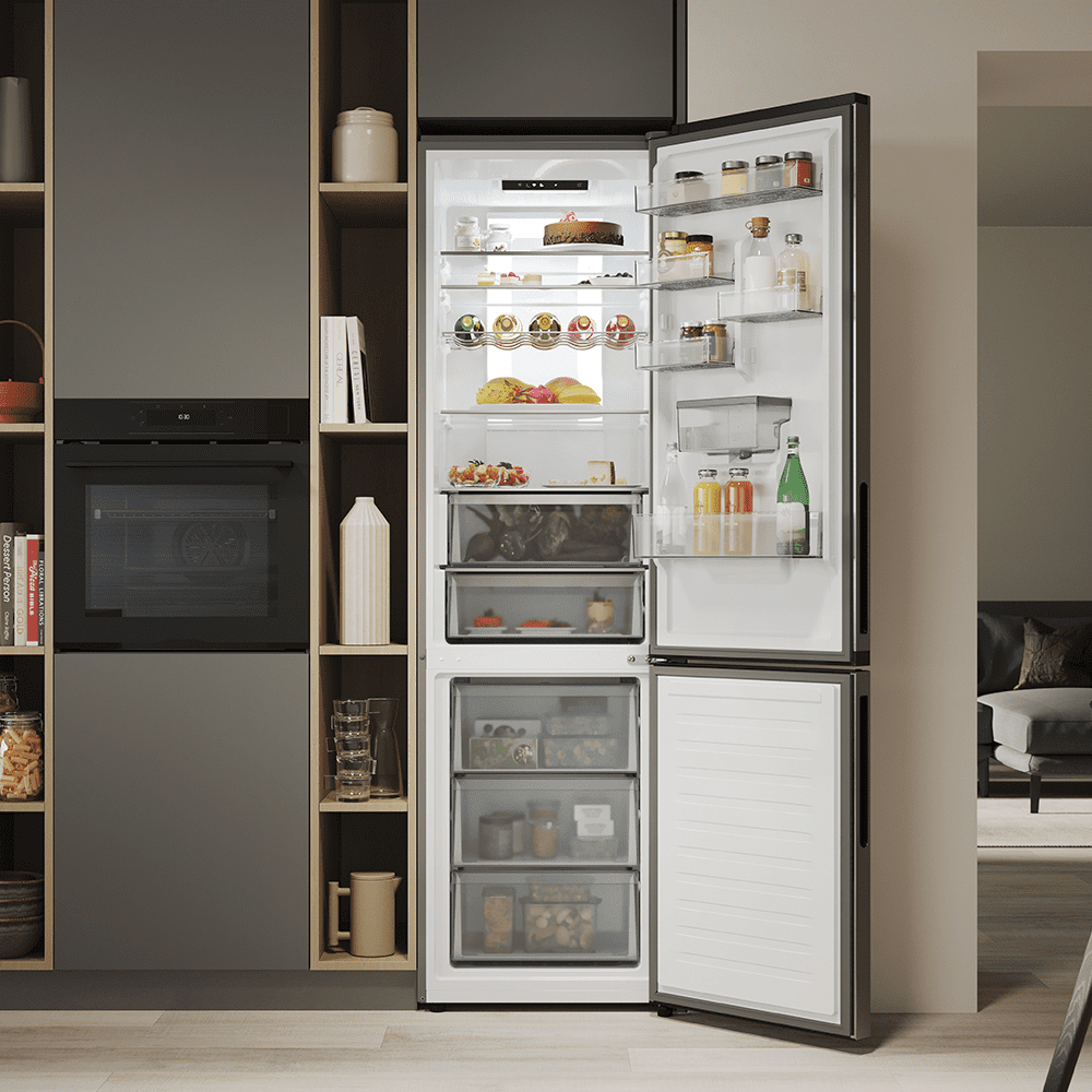 Image of a freestanding fridge freezer with the door open, showing a fully stocked interior.