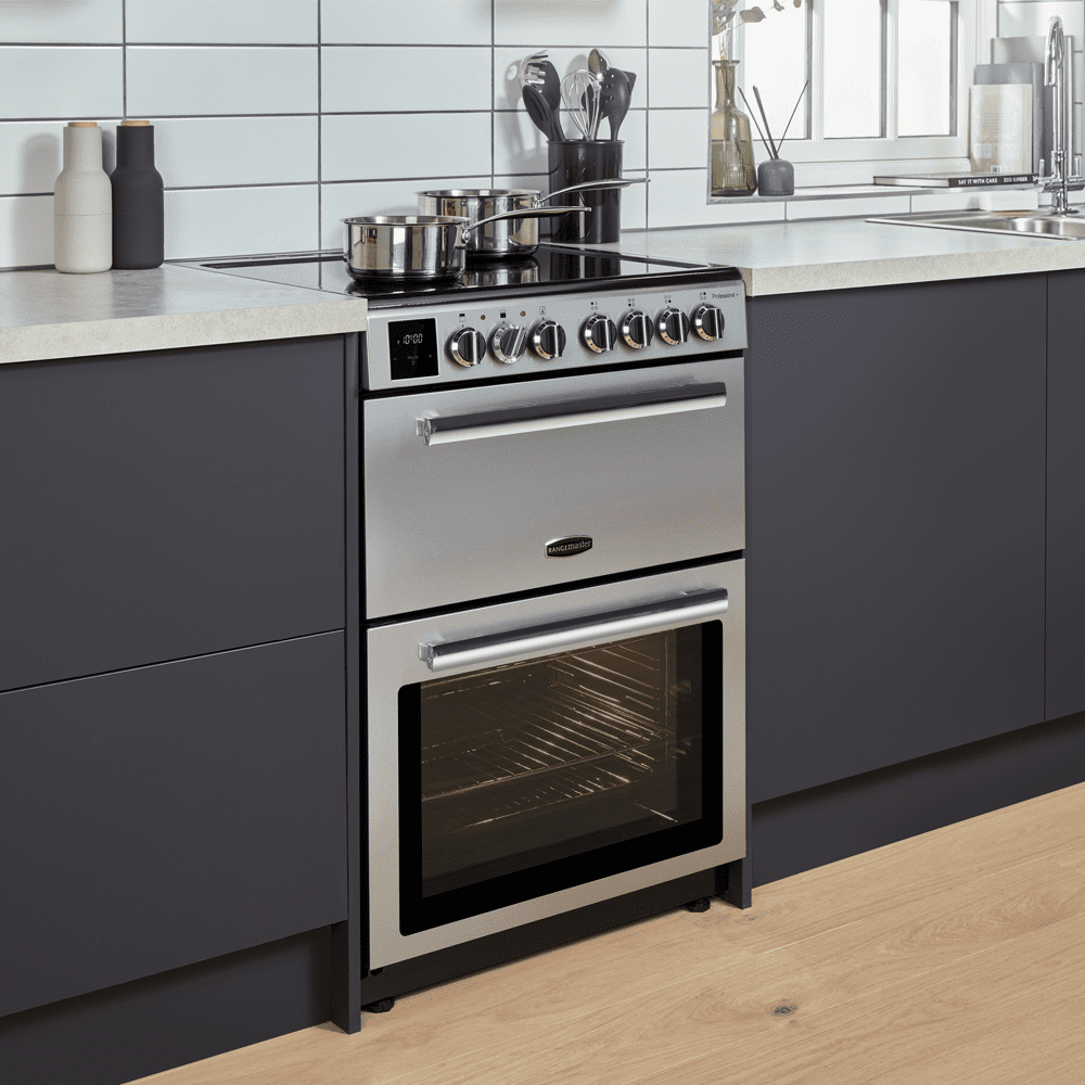 Close up of a Rangemaster induction freestanding cooker in stainless steel in a grey and white modern kitchen