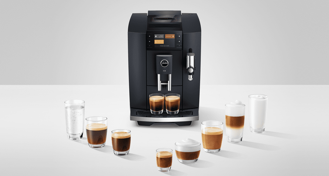 Jura E8 coffee machine finished in black, with several different speciality coffees in front of it