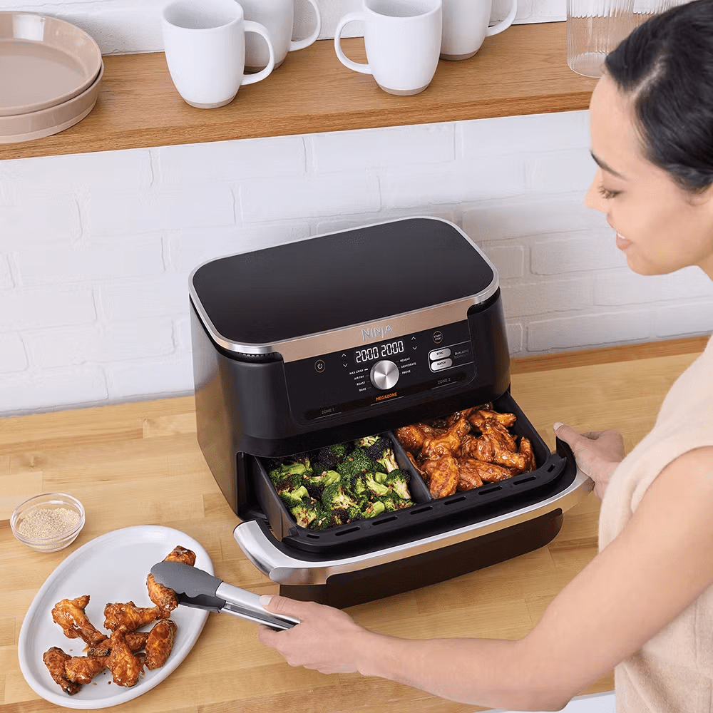 Image of a lady opening an air fryer filled with broccoli and fried chicken