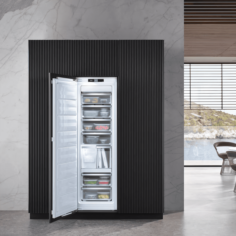 Image of a Miele integrated freezer with the door open showing the frozen goods inside.