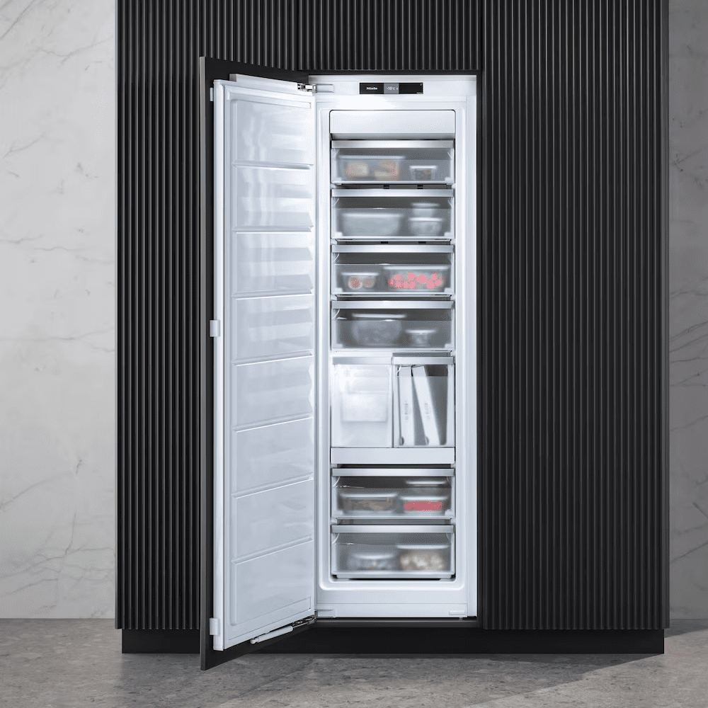 Image of a Miele integrated freezer with the door open showing the frozen goods inside.