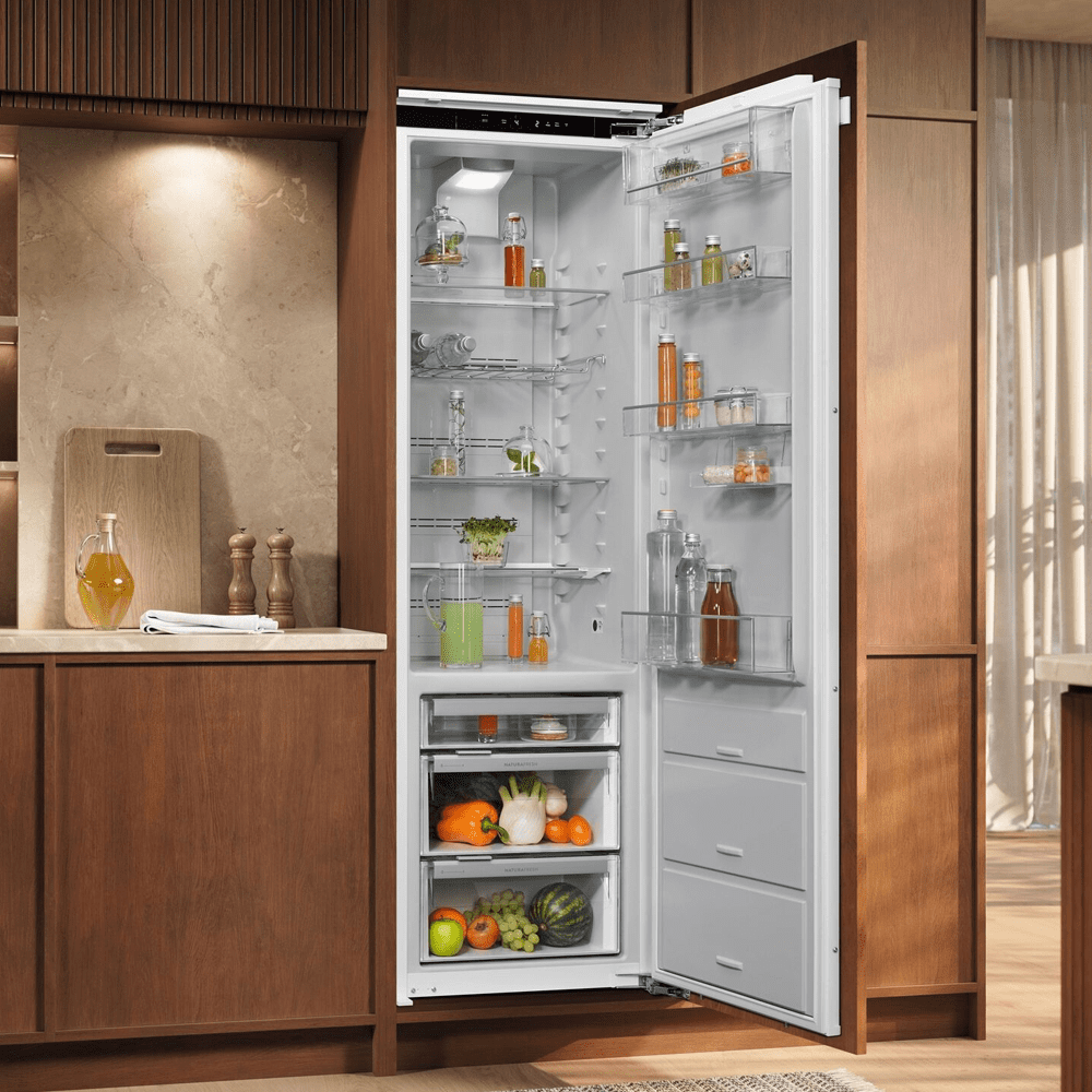 Image of an integrated AEG fridge with the door open, showing brightly coloured fruit and vegetables inside