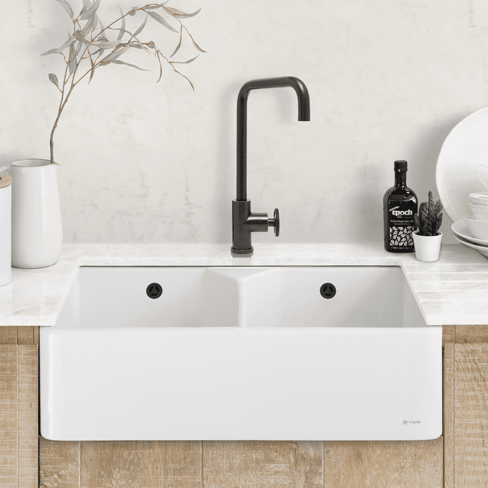 Image of a Caple white ceramic sit on sink in a white kitchen with white worktops and wooden cabinetry.