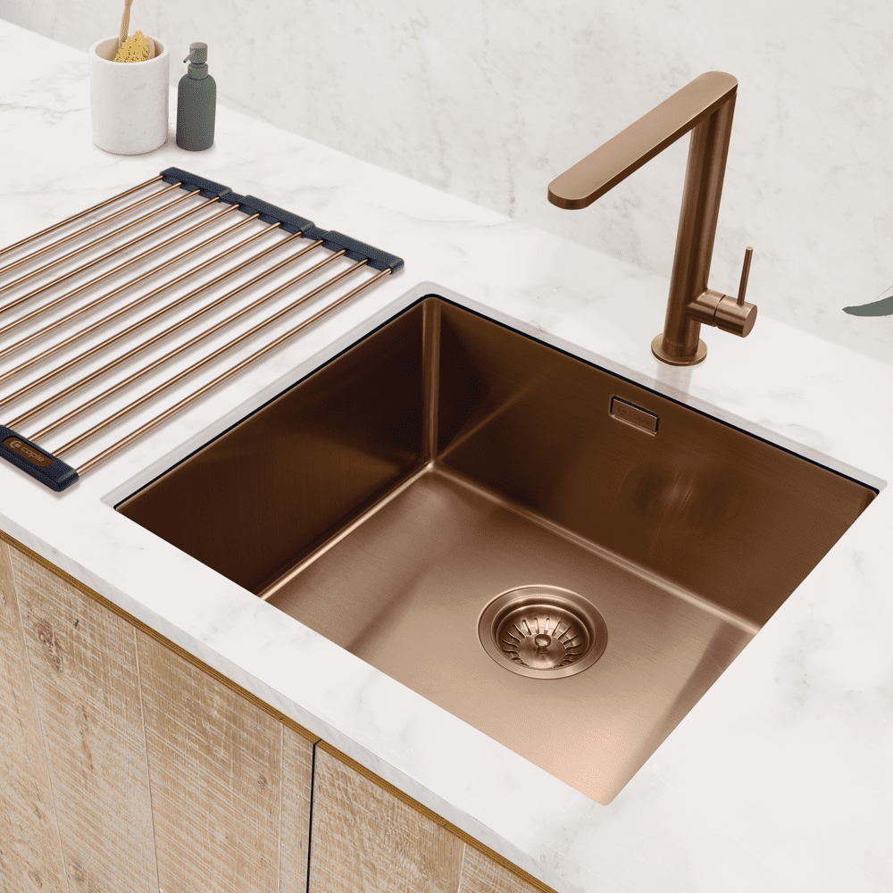 Close up of a Caple undermount copper sink with the matching tap and drainer.