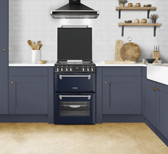 Stoves freestanding cooker in blue, fitted within a kitchen with extraction hood