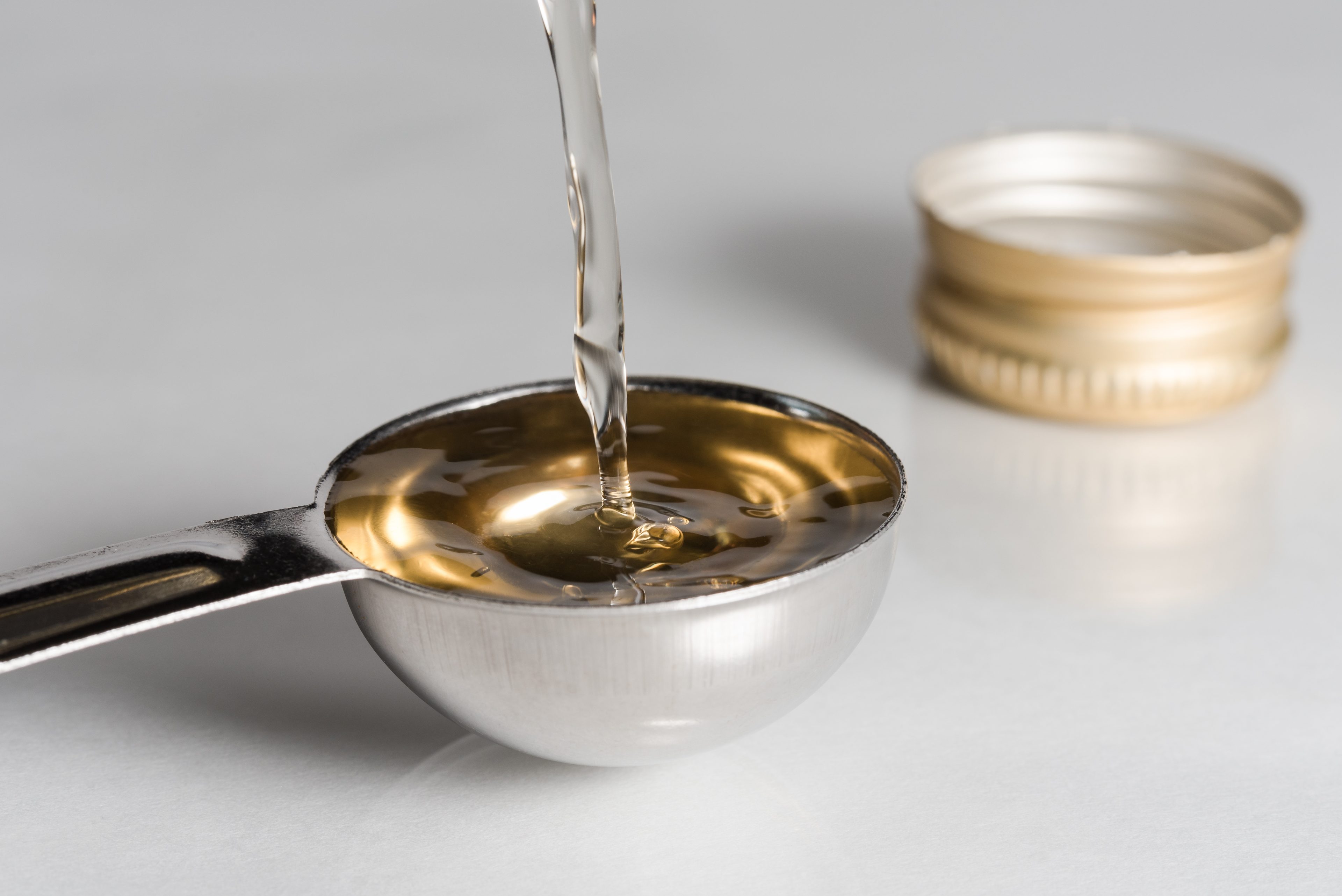 Vinegar being poured into a measuring spoon
